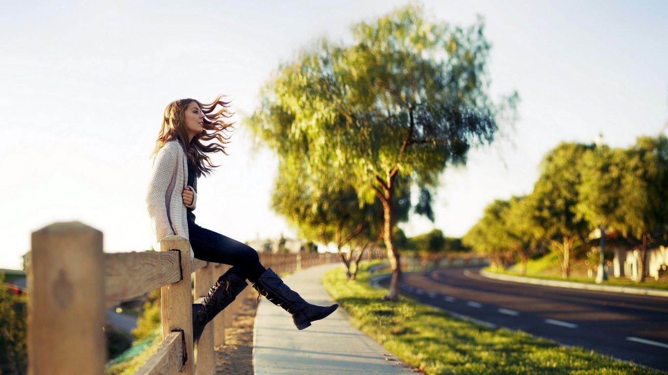 Girl Sitting On Fence and Looking Out Into Distance