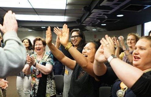 students with hands up at a life coaching event at the coaching institute